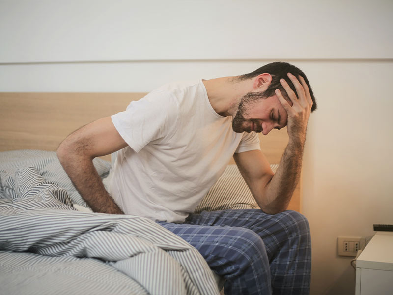 man waking up hungover in his bed