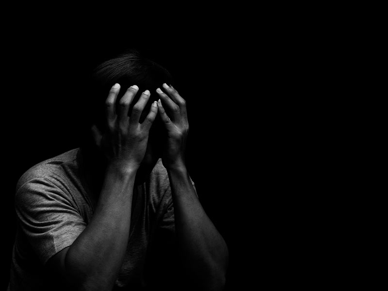 grayscale image of a man in a dark room experiencing benzodiazepine withdrawal